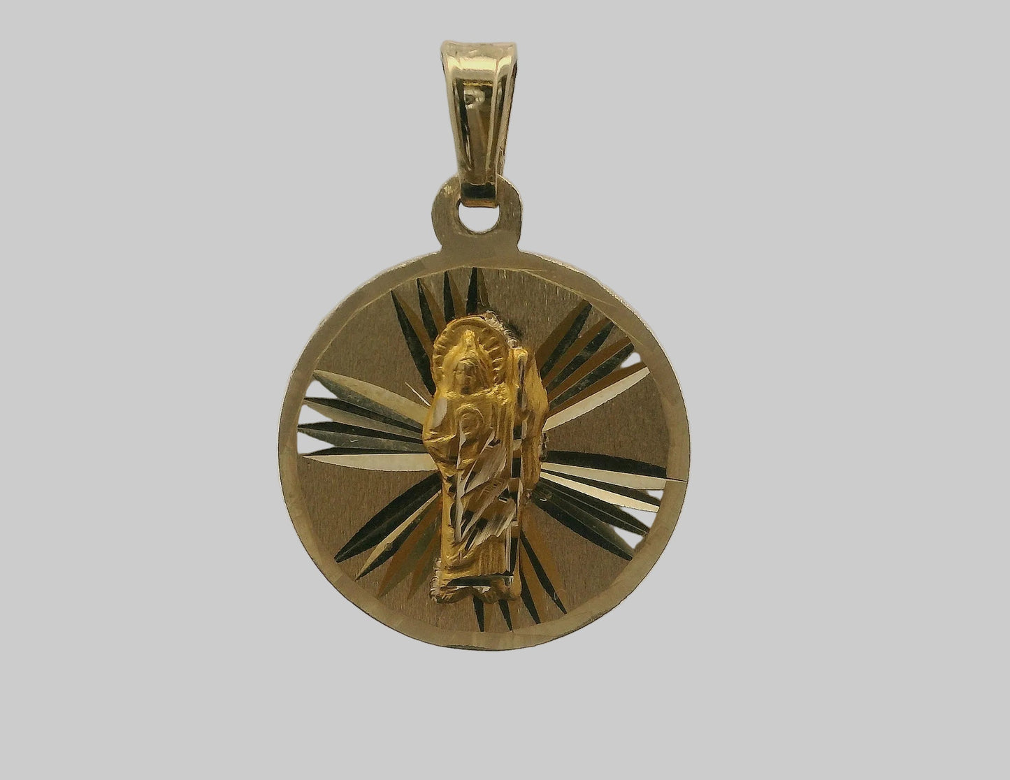 MEDALLA RELIGIOSA REDONDA DE ORO AMARILLO CON FIGURA EN RELIEVE Y DISEÑO DE RAYOS.